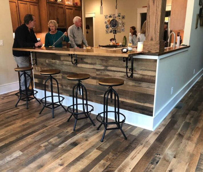 Reclaimed wood paneling in kitchen bar with folks gathered around.