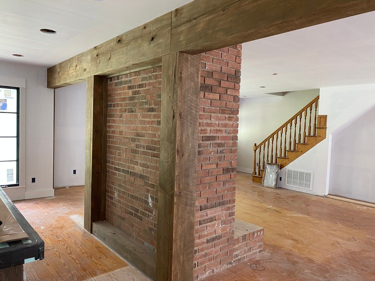 Circle sawn wood box beams surrounding brick fireplace