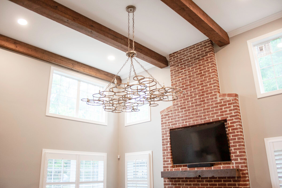 Circle sawn reclaimed box beam above brick fireplace