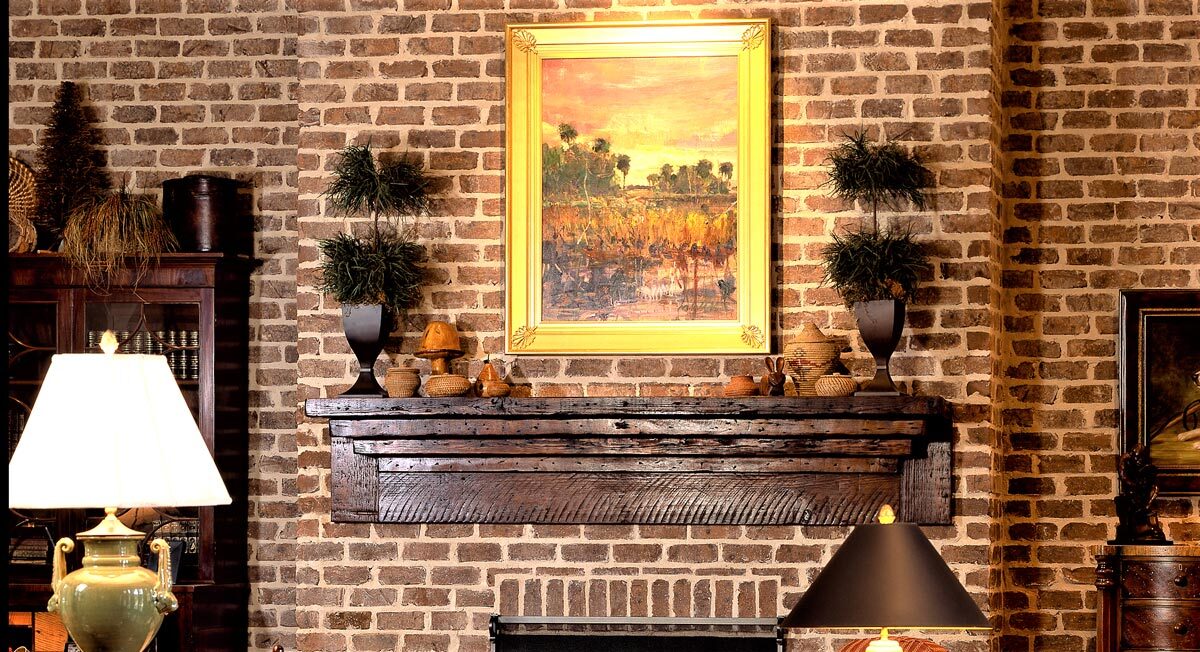 ornate custom  reclaimed wood mantel above a brick fireplace.