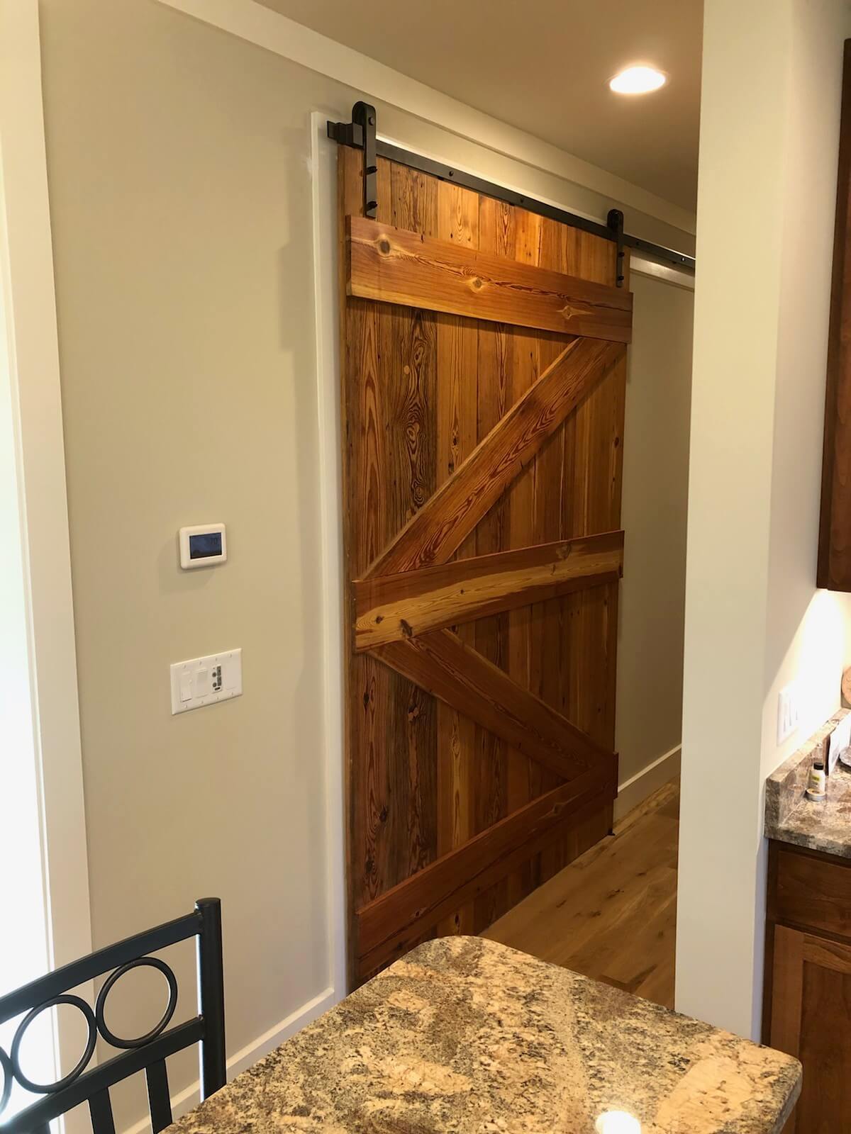 Smooth planed heart pine barn door on metal track