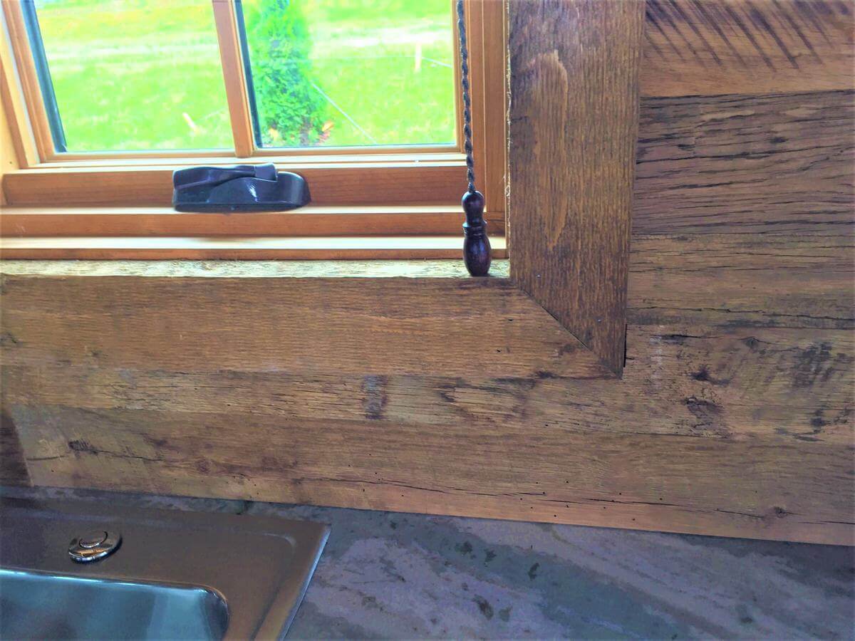 rustic wood window trim and wall cladding over a sink